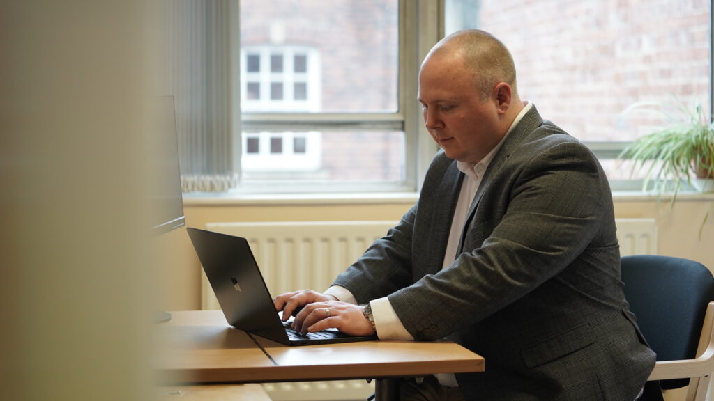 Male probation officer sitting at a desk facing the computer