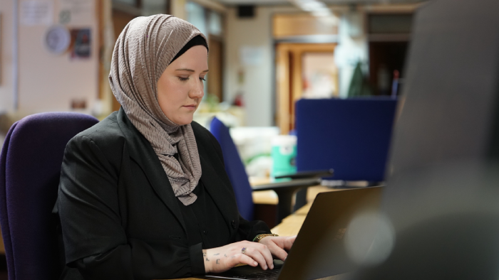 Female probation officer sitting at a desk facing the computer