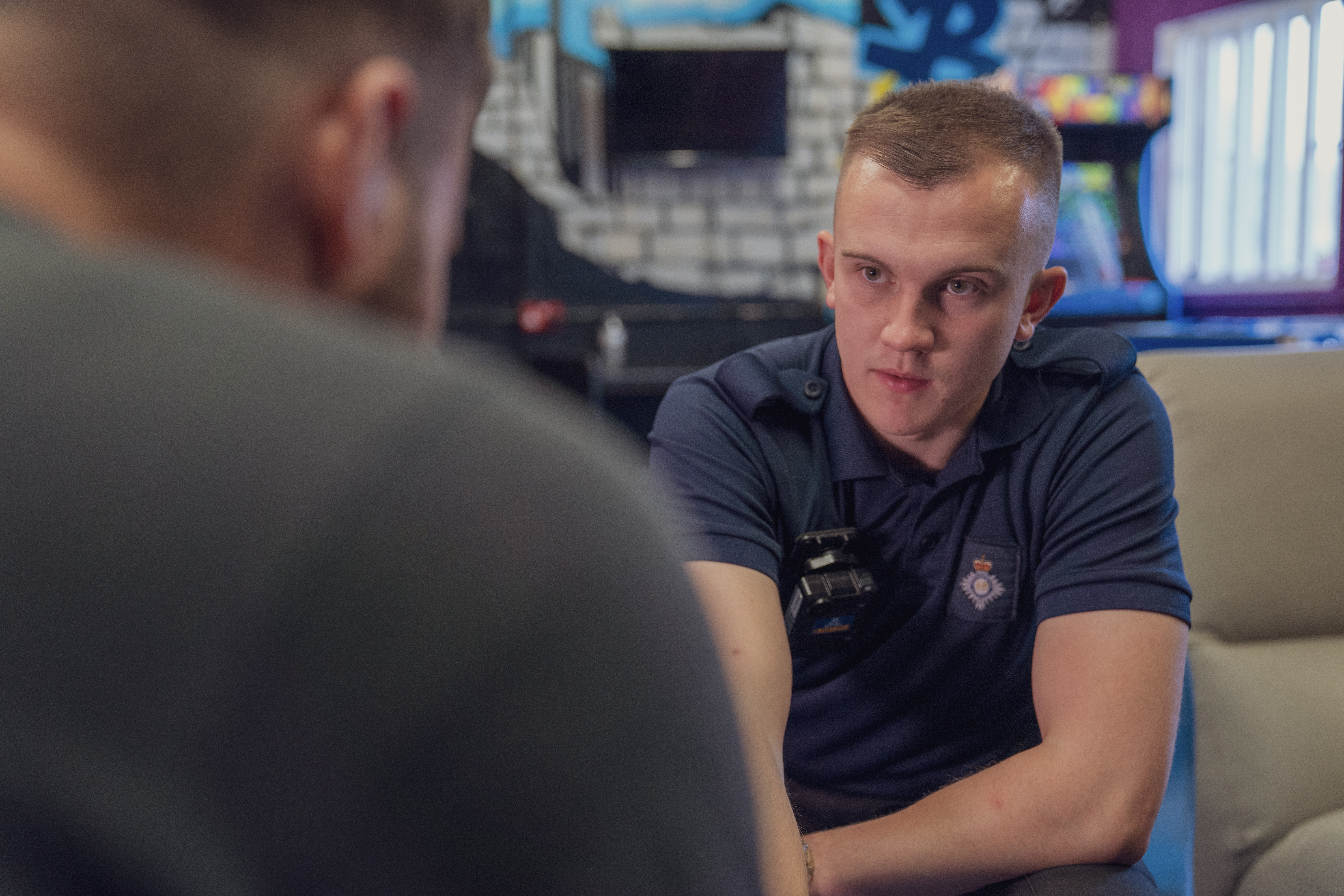 Male youth justice worker sitting talking to a young person