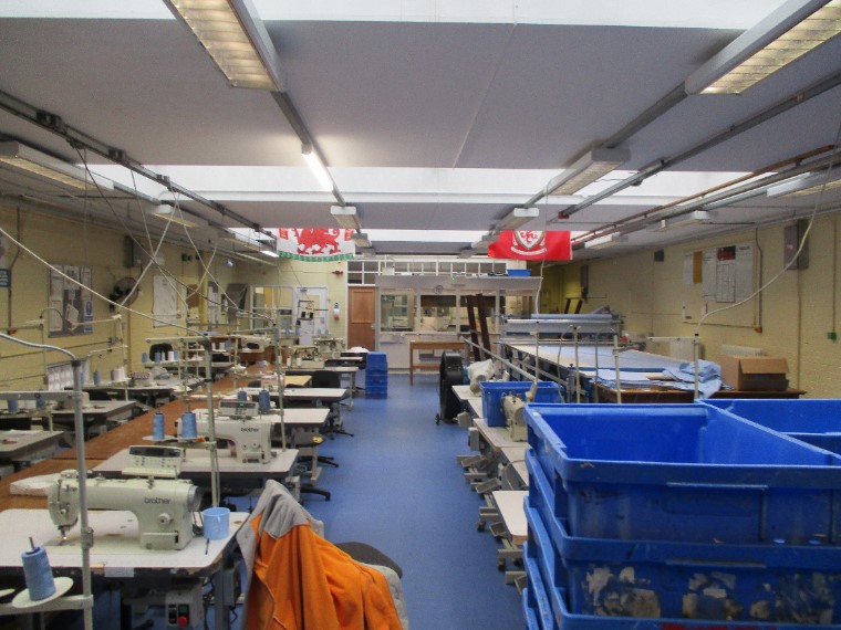 A tailoring workshop at Swansea prison with sewing machines and workstations