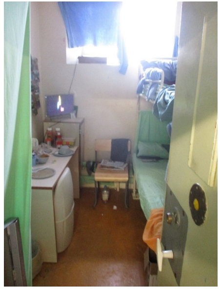 A cramped cell at HMP Dartmoor with bunk beds and prisoners' possessions