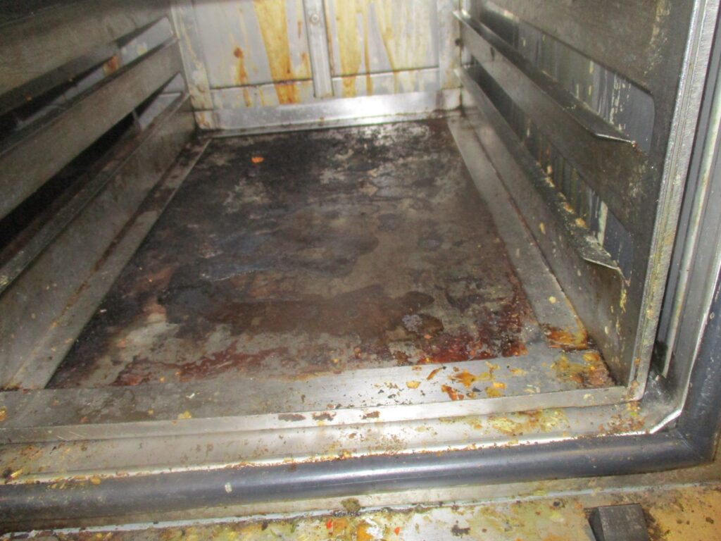Photo of a G wing food trolley. The image focuses on the inside of the trolley and it can be clearly seen that it is very dirty.