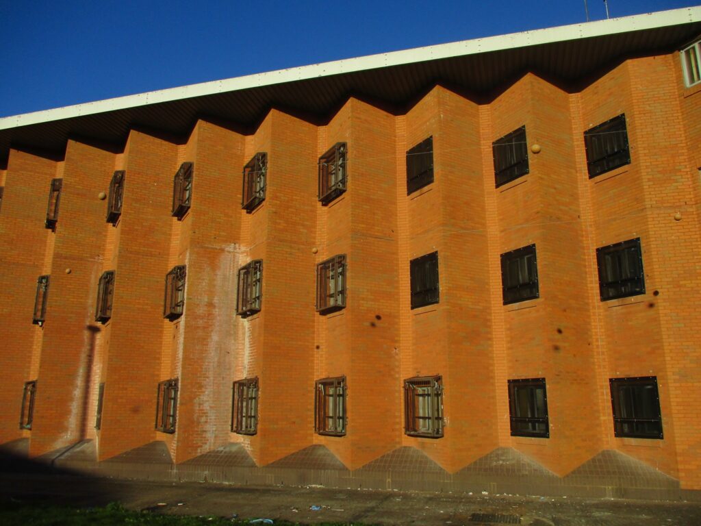 Photograph of the exterior of one of the buildings at HMP Woodhill. It is a three-storey buildings with windows along each floor.