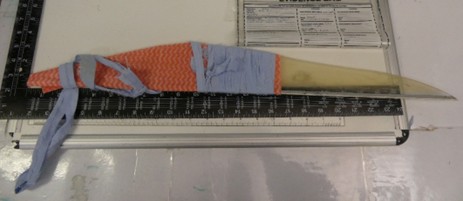 Photograph of an improvised weapon; a long-bladed, sharpened, plastic item made out of things available to a prisoner in a cell.