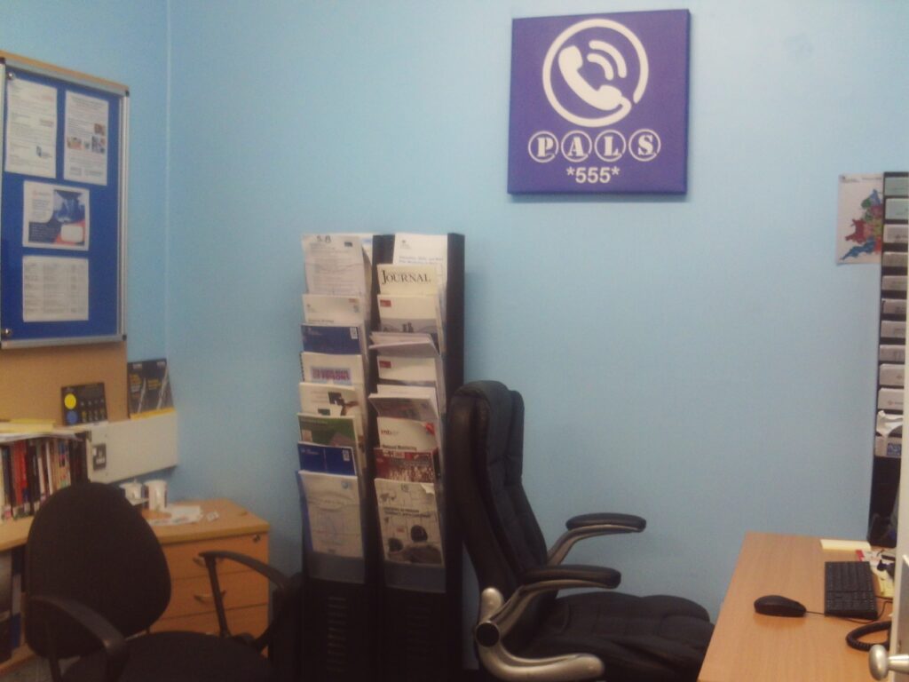 Photograph of the PALS room, with desks and chairs and a rack of information leaflets.