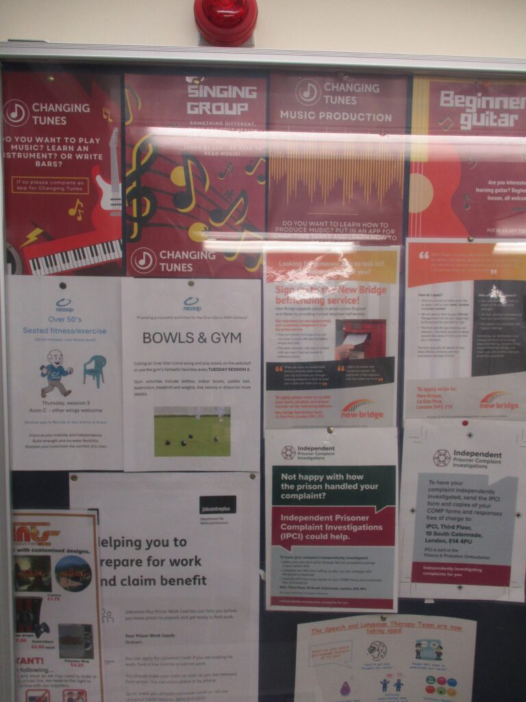 Photograph of a noticeboard on which information is displayed about a variety of activities that prisoners can take part in.