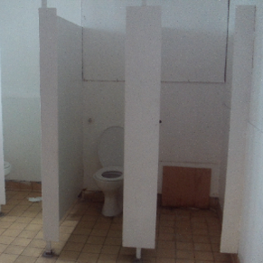 Photograph showing toilets in reception. Thee are in a poor condition, with one toilet missing from a cubicle.
