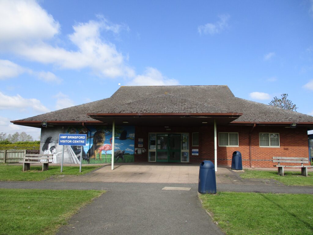 Photograph of the exterior of the visitors' centre; a one-storey brick building with a pitched roof.