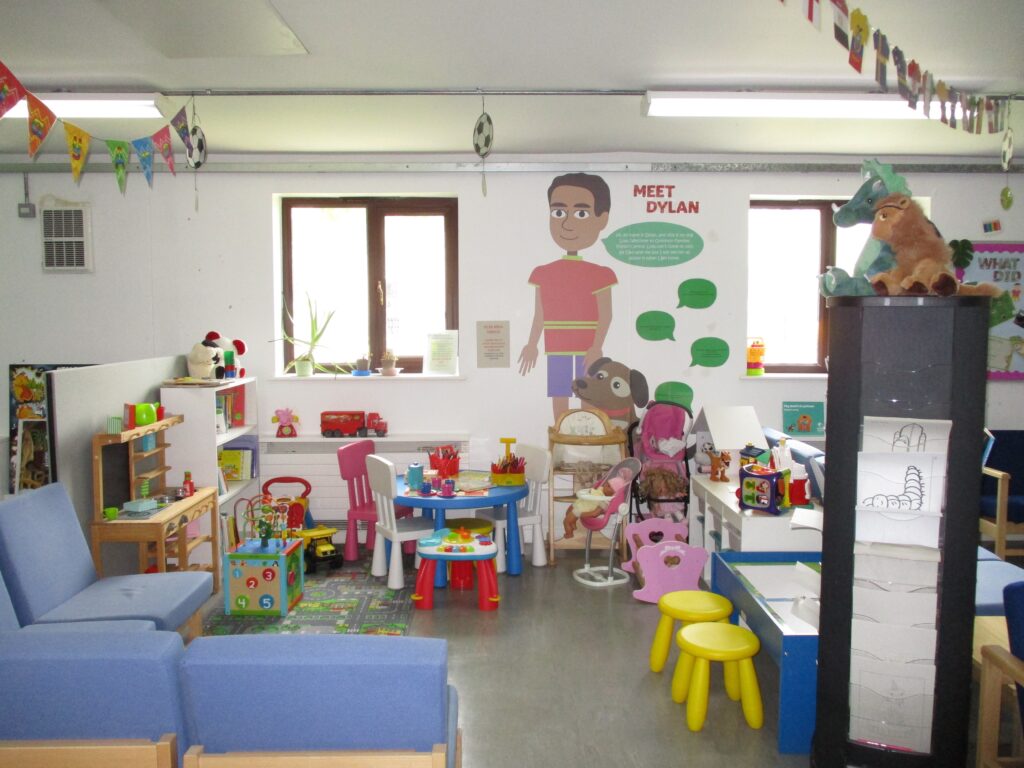 Photograph of the children's play area in the visitor centre. Child-sized tables and chairs, and toys and games can be seen.