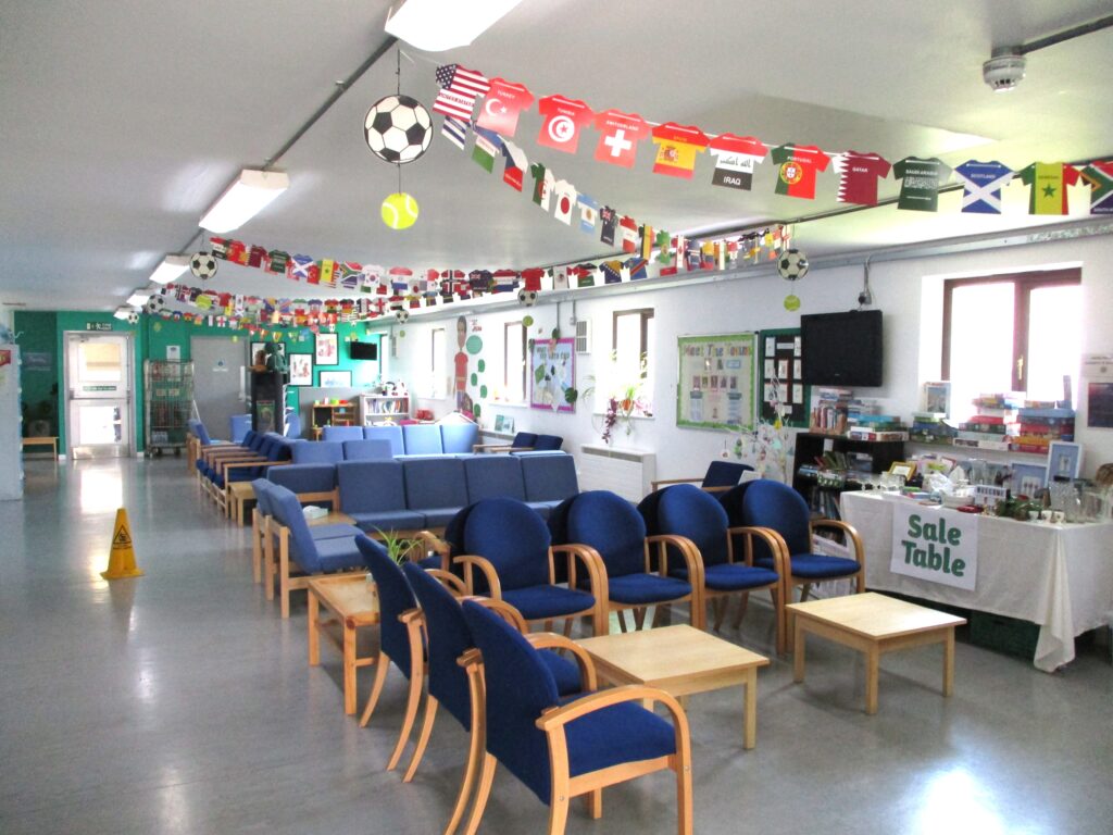 Photograph of the interior of the visitor centre; a long room with tables, chairs and decoration on the walls and ceiling.