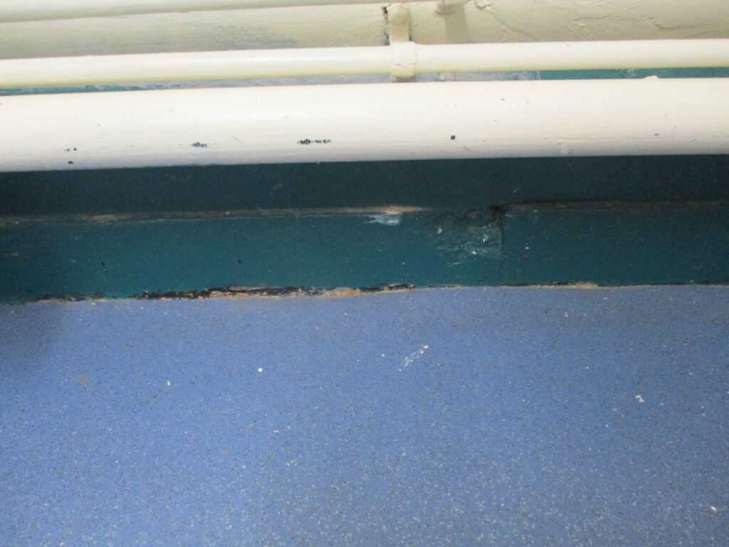Photograph of damaged flooring in a clinical room.