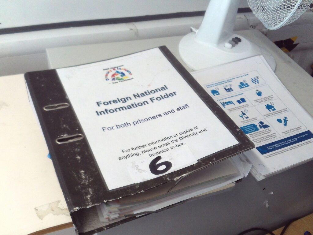 Photograph of a folder with a piece of paper stuck to its cover. ON it are printed the words: ' Foreign National Information Folder'.