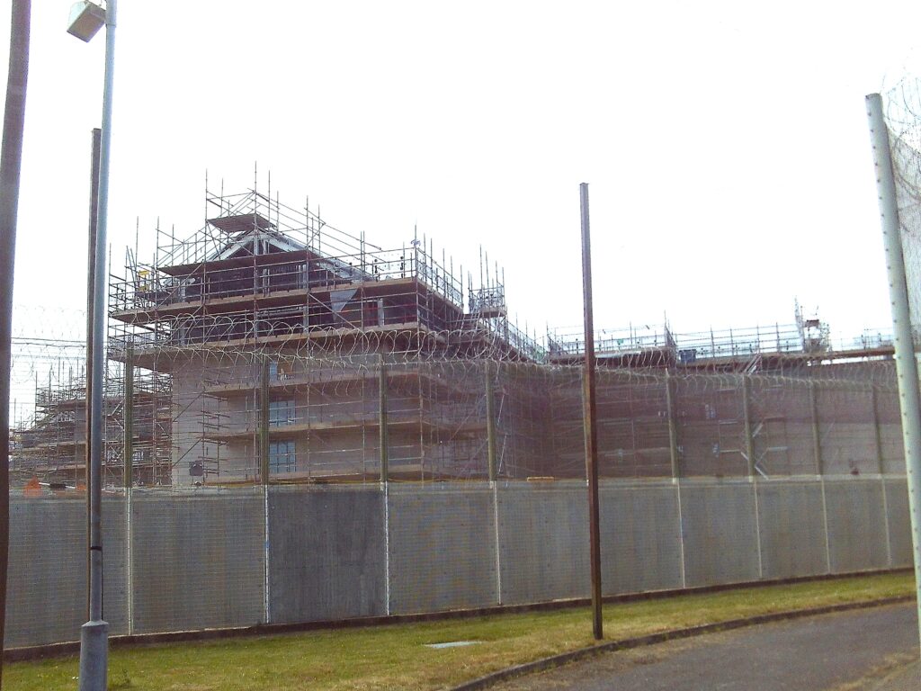 Photograph of a new residential unit being constructed. The building is several floors high and surrounded by scaffolding.