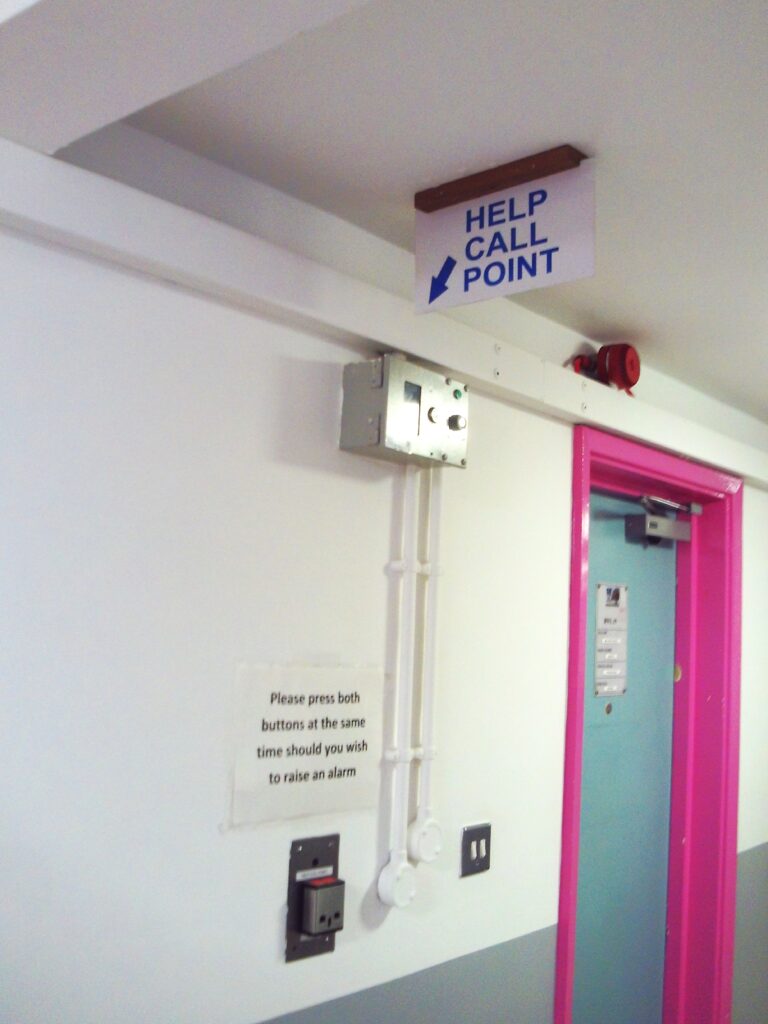 Photograph of the help call point, a wall-mounted system.