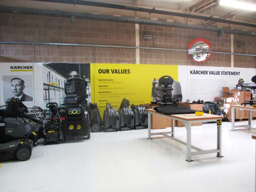 Photographs of the Karcher workshop, a light industrial space with workbenches and equipment in the foreground, and visual displays explaining Karcher's values in the background.
