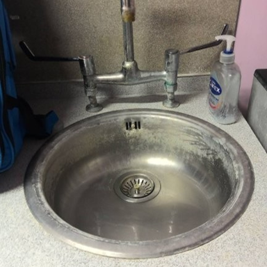 Photograph showing a stainless-steel sink and faucet installed in a countertop.