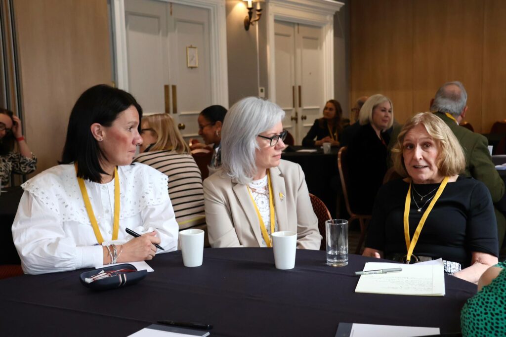 Three participants at the NPM conference in a conversation.