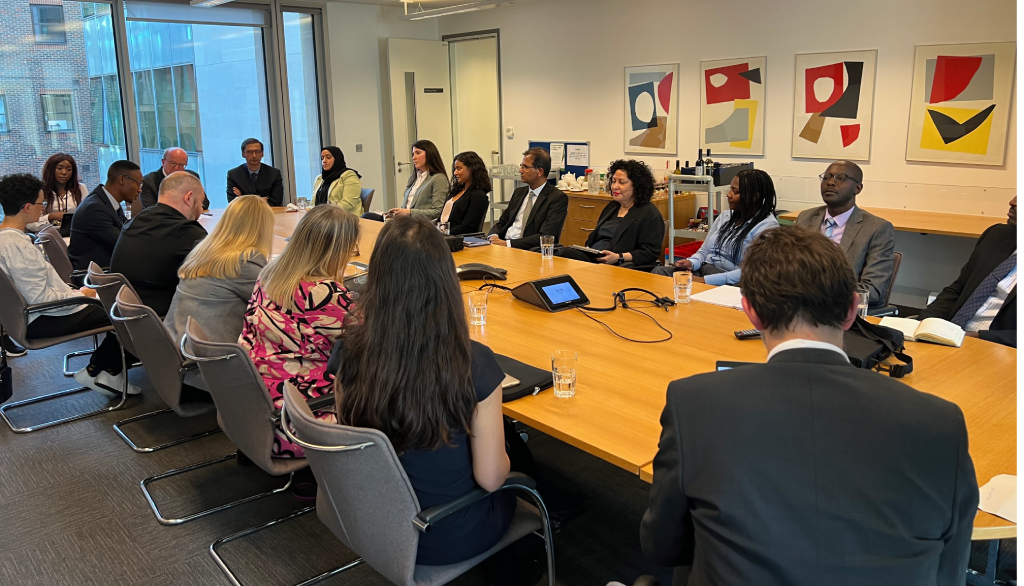 Judges of the observation programme attending a meeting with the profession. All are sat around a large table