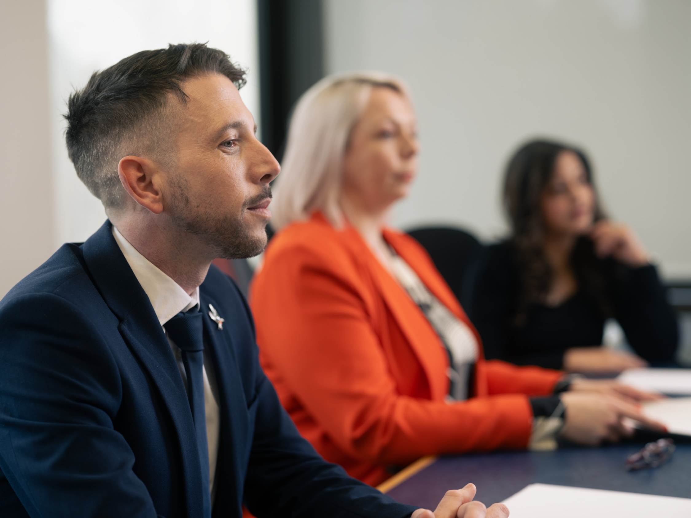 Three magistrates sitting in court on a bench. One white male, one white female and one Asian female