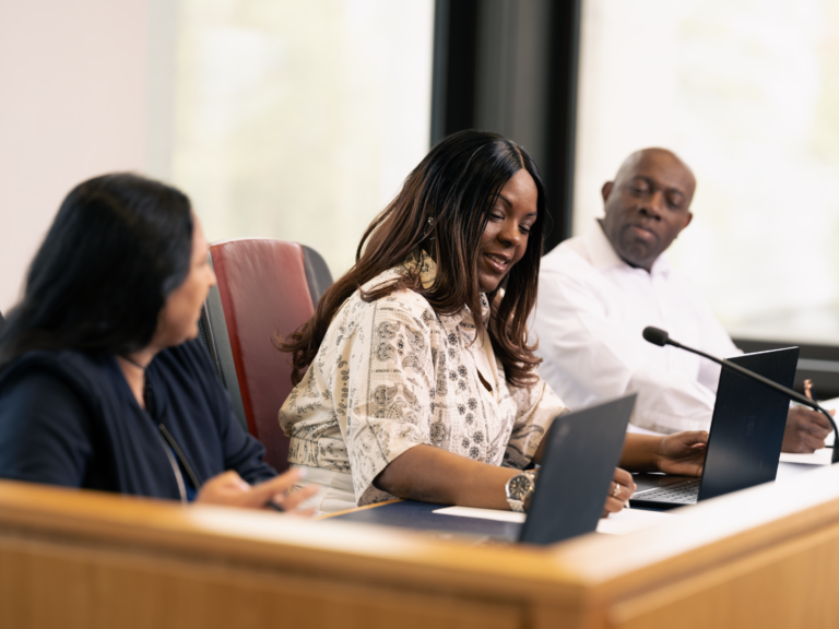 Three magistrates sitting in court on a bench. One Asian female, one black female and one black male