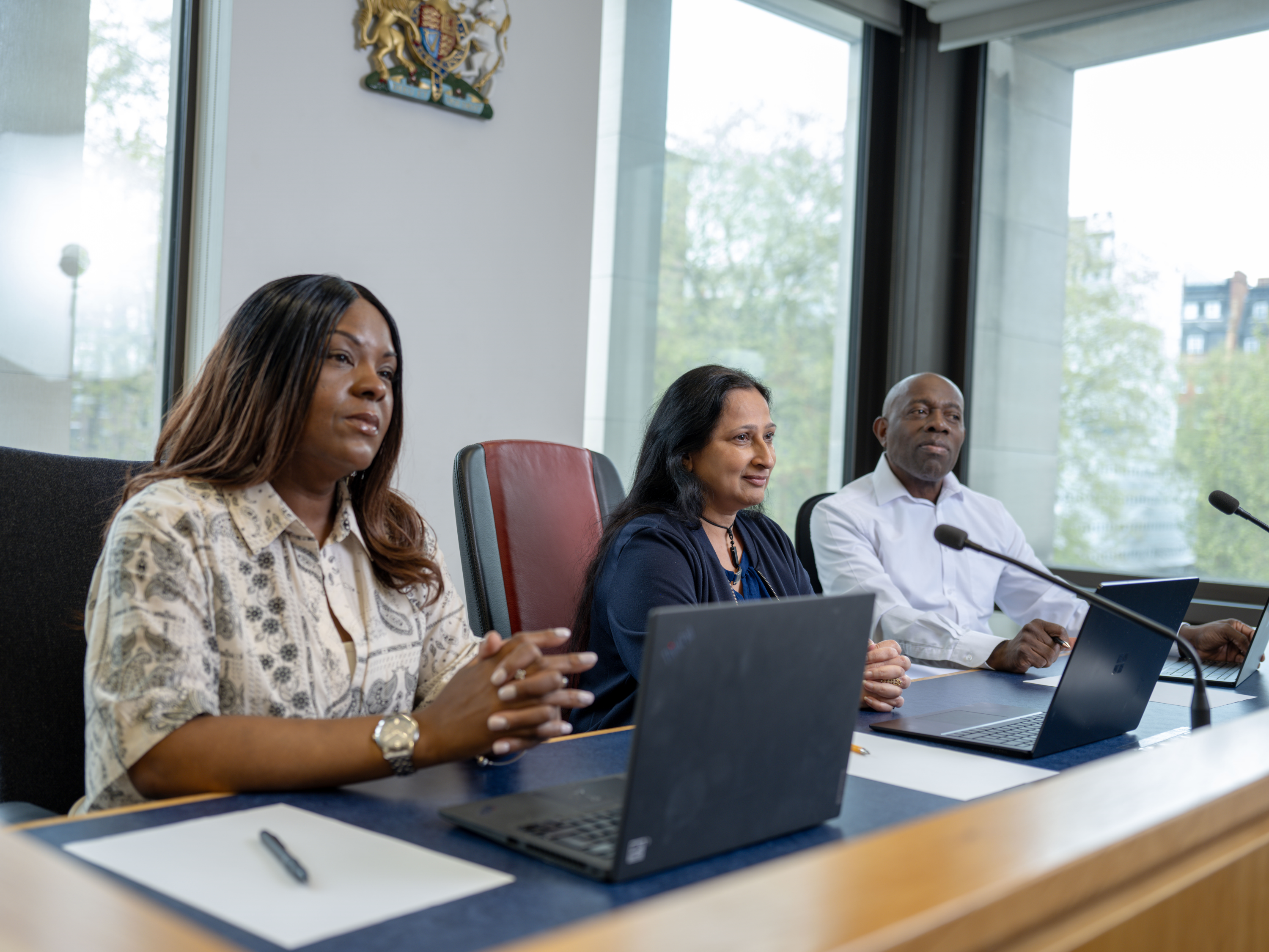 Three magistrates sitting in court on a bench. One black female, one Asian female and one black male