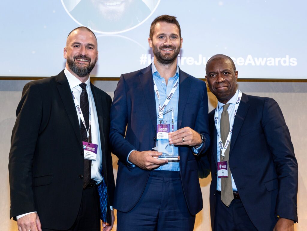 Image showing HM Inspector Dave Argument (centre) collecting his Inspectorate Staff Member of the Year award from Tom Wheatley, Prison Governors Association (left) and Clive Myrie, host (right)