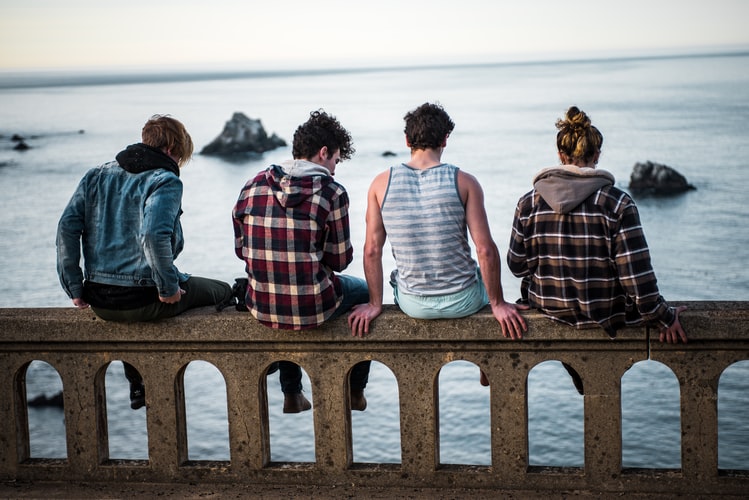 Four young adults sat on a bench