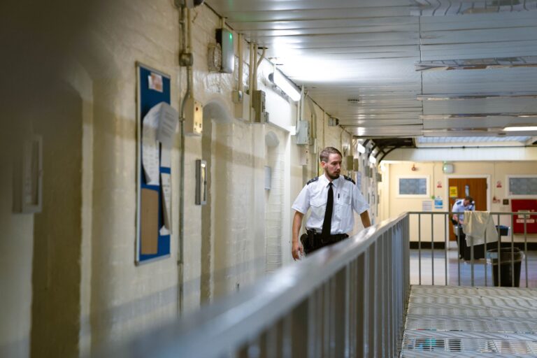 Image of a prison officer walking down a corridor.