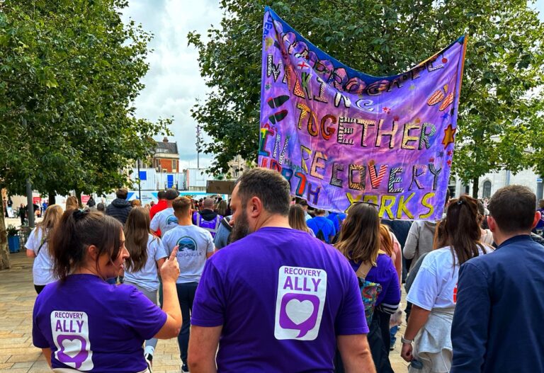 Image of a march in the street with recovery advocates