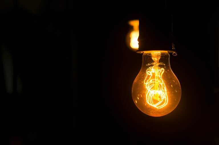 Stock photo of a glowing lightbulb in a dark room