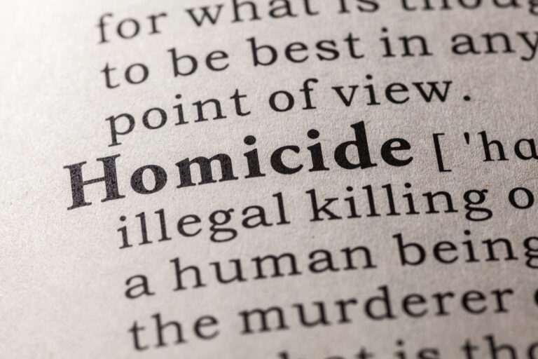 Image of a dictionary open at the entry for 'homicide'.