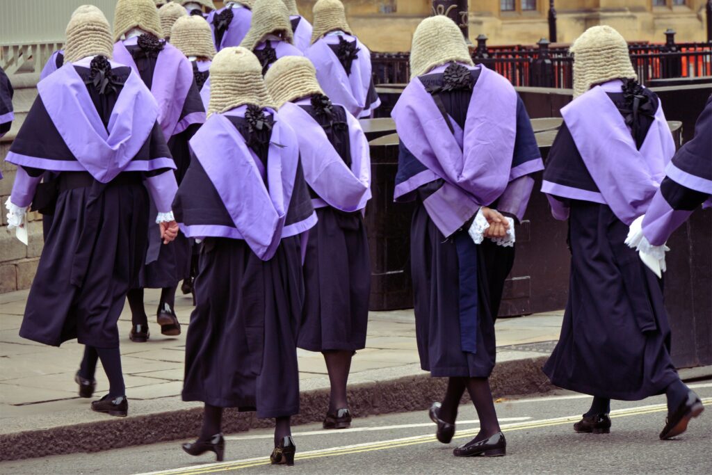 Image showing a group of judges, wearing robes and wigs walking towards a court building